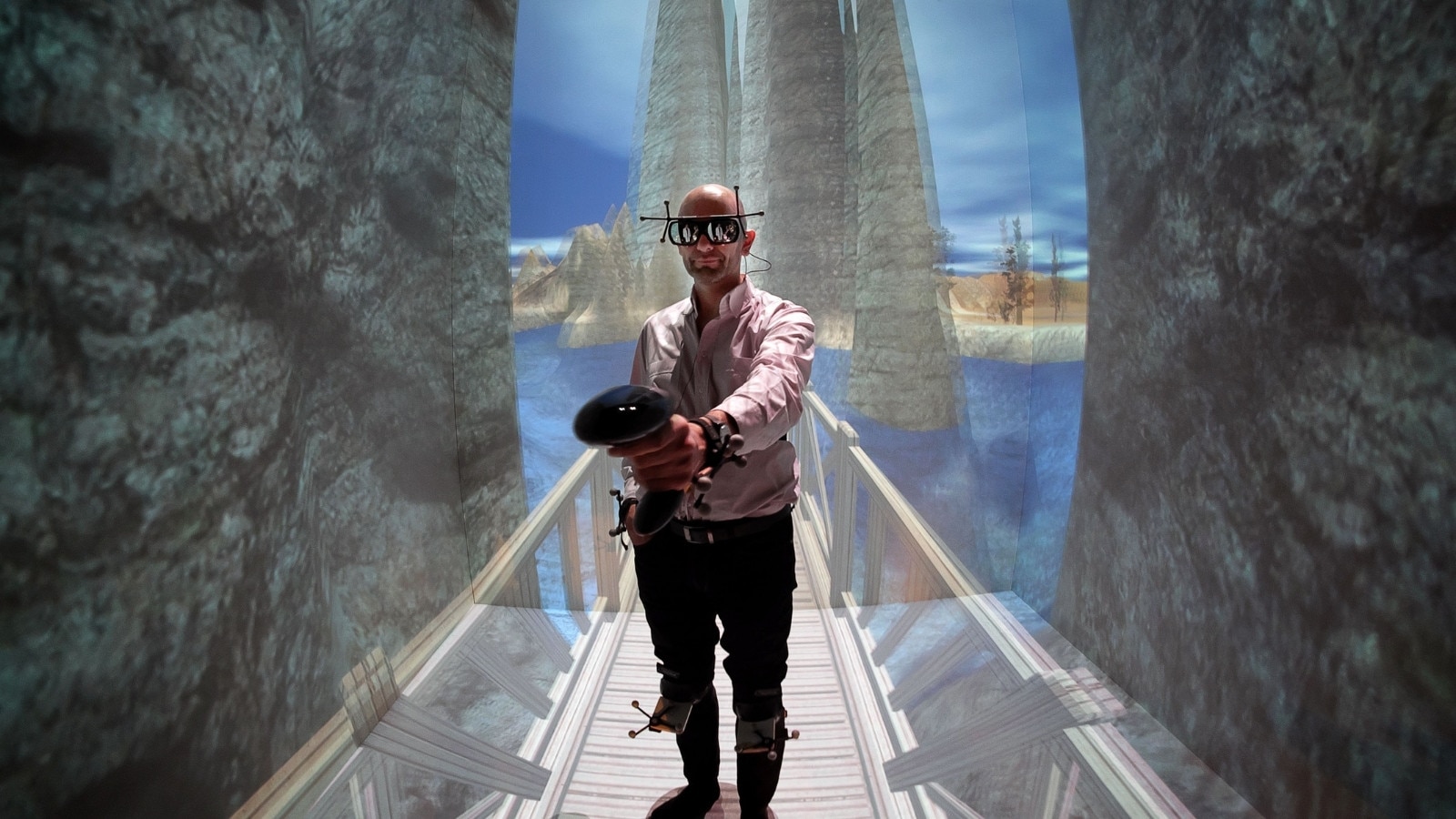 A man walking while wearing a VR headset and holding a controller in his hand